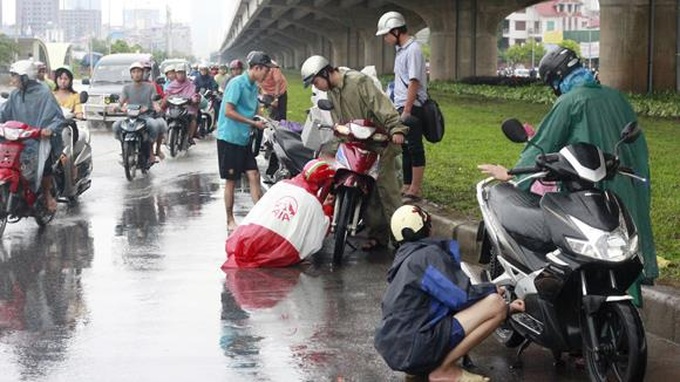 Đang đi trên đường, dừng xe để mặc áo mưa có phạm luật không? - 1